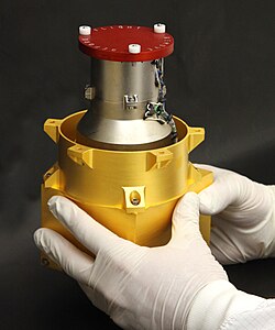 A lab tech holding the RAD, only the top rim of which is visible from outside the rover body