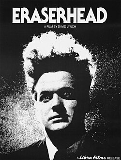 Black and white image of a man with long wild hair standing straight up, as if electrocuted like a cartoon