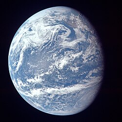 A view of Earth with its global ocean and cloud cover, which dominate Earth's surface and hydrosphere; at Earth's polar regions, its hydrosphere forms larger areas of ice cover.