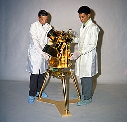 Dr. George Carruthers, right, and William Conway, a project manager at the Naval Research Institute, examine the gold-plated ultraviolet camera/spectrograph, the first moon-based observatory that Carruthers developed for the Apollo 16 mission.