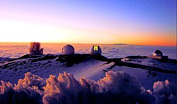 Sunset over four telescopes of the Maunakea Observatories. From left to right: the Subaru Telescope, the twin Keck I and II telescopes, and the NASA Infrared Telescope Facility.