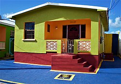 A small house prominently coloured in red, green, and orange
