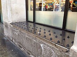 Anti-homeless spikes on a shop ledge.