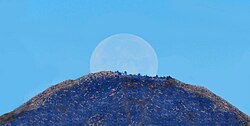 A full moon sets behind San Gorgonio Mountain in California on a midsummer's morning.