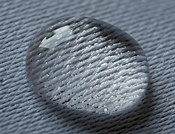 Water droplet lying on a damask. Surface tension is high enough to prevent seeping through the textile