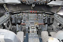 The nose gear tiller is visible as a semi-circular manual control to the left of the yoke in this photo of a Boeing 727 cockpit.