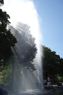 Water escapes at high speed from a damaged hydrant that contains water at high pressure (due to high pressure of the water it behaves like it is sprayed)