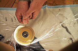 Sparks from a screw held on a grinder