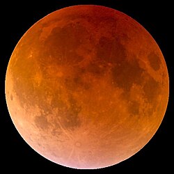 Photo of large, reddish Moon during a lunar eclipse