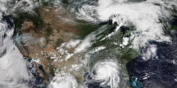 Satellite image of the Contiguous United States, with wildfires in the west, Hurricane Ida off the coast of Louisiana, and a line of thunderstorms developing over the Great Lakes region during late summer