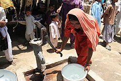 A woman pumps water from a handpump in her village in Sindh, Pakistan