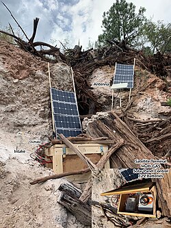 Multi-GAS permanent field station. Set-up consists of a Multi-GAS, satellite terminal, 12V batteries, and solar panel control located inside the wooden box. Satellite antenna, solar panels, and multi-GAS intake/outtake located outside of the box.