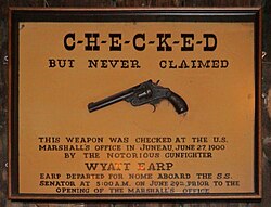 The pistol was said to be Wyatt Earp's, left behind in Juneau, Alaska, but he was arrested in Nome three days before the date on the sign