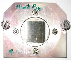 A square beryllium foil mounted in a steel case to be used as a window between a vacuum chamber and an X-ray microscope. Beryllium is highly transparent to X-rays owing to its low atomic number.