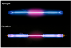 Hydrogen (above) and deuterium (below) glowing in gas discharge tubes