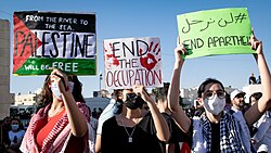 Arab women protestors holding pro-Palestinian signs in front of the Israeli embassy in Amman, 2021