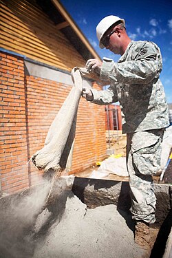 Cement powder being poured from a bag, ready to be mixed with aggregates and water.[1]