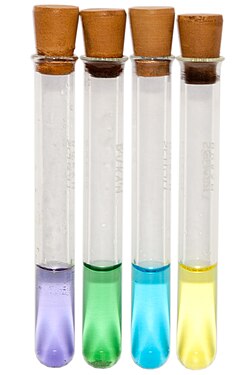 From left: [V(H2O)6]2+ (lilac), [V(H2O)6]3+ (green), [VO(H2O)5]2+ (blue) and [VO(H2O)5]3+ (yellow)