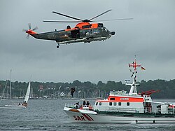 A cruiser of the DGzRS and a SeaKing helicopter of the German Navy