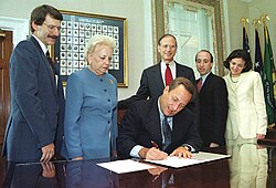 Withrow and other Treasury officials watch Secretary Summers affix his signature to new currency, 1999