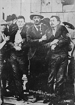Law enforcement officers hold up the bodies of Bob and Grat Dalton after the attempted Bank Robbery in Coffeyville, Kansas