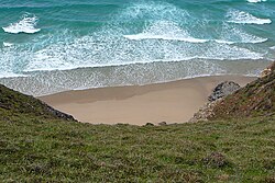 Water waves are almost parallel to the beach when they hit it because they gradually refract towards land as the water gets shallower.