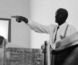Till's uncle, Mose Wright, identifying J. W. Milam during Milam's trial, an act that "signified intimidation of Delta blacks was no longer as effective as [in] the past".[101] Wright had "crossed a line that no one could remember a black man ever crossing in Mississippi".[102] Photojournalist Ernest Withers defied the judge's orders banning photography during the trial to capture this shot.