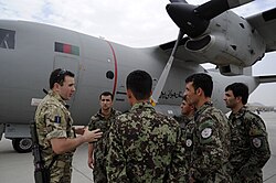 United Kingdom's Royal Air Force Flight Lieutenant Luke Meldon explains the components of an Afghan Air Force (AAF) C-27 Spartan to five Thunder Lab students.
