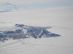 Aerial view of the tip of Hut Point Peninsula with McMurdo Station on the near side and Scott Base on the far side. Mount Terror in the background