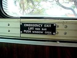 Operation guide metal plate for emergency exits installed in the school bus window.