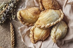 Philippine fried empanadas, with ground beef, potatoes, carrots, cheese, and raisins in a thin, crisp crust