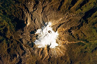 The volcano's summit and upper flanks are covered by several glaciers that appear as a white mass surrounding the Arenas crater.