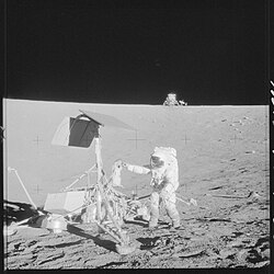 An example of the robotic and human exploration of the Moon in the first visit of a separate mission beyond Low Earth Orbit (1969),[288] Apollo 12 astronaut Pete Conrad checking on Surveyor 3 at their shared lunar base, with the Apollo 12 Intrepid lander and S-band antenna in the distant background