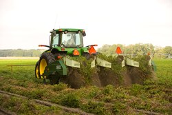 A tractor being used to complete the first stage of the peanut harvesting process
