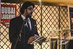 Comedian Osman Rohail performing a roast at a comedy club in Dubai