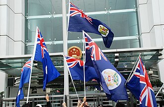 Protesters waving Hong Kong colonial flag outside the Chinese Hong Kong Liaison Office in 2019