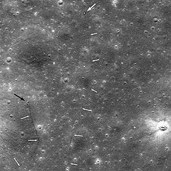 Lunar Reconnaissance Orbiter image of Lunokhod 2 and its tracks. The large white arrow indicates the rover, the smaller white arrows indicate the rover's tracks, and the black arrow indicates the crater where it picked up its fatal load of lunar dust.