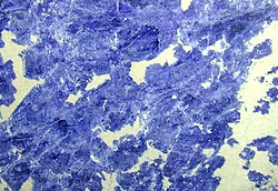 A sample of sodalite-carbonate pegmatite from Bolivia, with a polished rock surface.