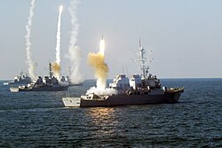 Arleigh Burke-class guided missile destroyers use their Vertical Launch Systems to fire Standard missiles during a live fire exercise.