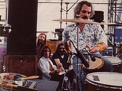 Grateful Dead members in the early 1980s: Brent Mydland, Bob Weir, and Jerry Garcia watch Bill Kreutzmann play the drums.