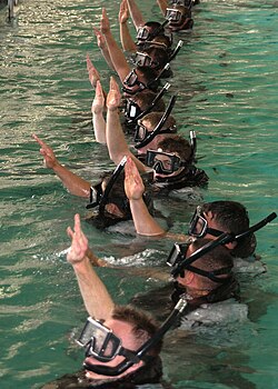 Search and Rescue students give the "I am all right" signal to let the SAR instructors know that they are ready for further instructions at the pool on board Naval Station San Diego.