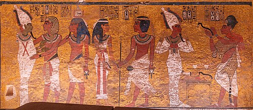 Scenes from the north wall of the burial chamber of Tutankhamun. On the left side, Tutankhamun, followed by his ka (an aspect of his soul), embraces Osiris.[27]