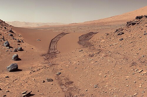 Curiosity's view of Martian soil and boulders after crossing the "Dingo Gap" sand dune (February 9, 2014; image transformed to Earth-like atmospheric view, original image).
