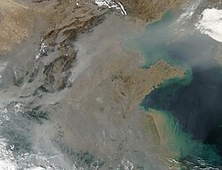 Satellite photo showing a thick pall of smoke and haze from forest fires in Eastern China. Such smoke is full of black carbon, which contributes to dimming trends but has an overall warming effect.