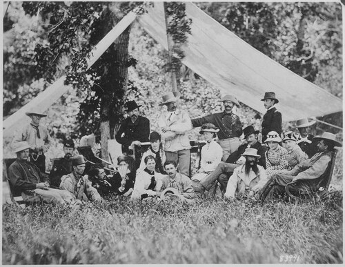 Hunting and camping party near Fort Abraham Lincoln, 1875. An illustration of the variety of uniforms worn by Cavalry Regiments in the west. From left to right: Lt. James Calhoun, Mr. Swett, Capt. Stephen Baker, Boston Custer, Lt. Winfield Scott Edgerly, Miss Watson, Capt. Myles Walter Keogh, Mrs. Maggie Calhoun, Mrs. Elizabeth Custer, Lt. Col. George Custer, Dr. H.O. Paulding, Mrs. Henrietta Smith, Dr. George Edwin Lord, Capt. Thomas Bell Weir, Lt. William Winer Cooke, Lt. R.E. Thompson, Miss; Wadsworth, another Miss Wadsworth, Capt. Thomas Custer and Lt. Algernon Emery Smith.[50]