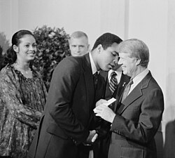 President Jimmy Carter greets Ali, along with his wife Veronica Porché, at a White House dinner, 1977.
