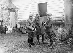 Soldiers celebrating Christmas on the western front, December 1916. Each has a sprig of mistletoe attached to his cap.