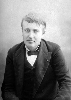 Edison at 42 in a highly focused portrait peers into the camera. This bored looking man with neat hair is finely dressed with a bow tie, stiff collar, and layered lapels.