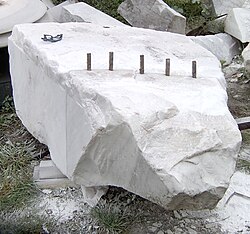 Splitting a block of marble with plug and feathers