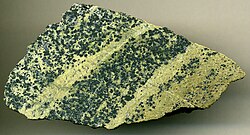 Chromitic serpentinite (7.9 cm (3.1 in) across), Styria Province, Austria. Protolith was a Proterozoic-Early Paleozoic upper mantle dunite peridotite that has been multiply metamorphosed during the Devonian, Permian, and Mesozoic.
